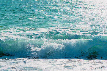  Sandy coast with a beautiful splash wave. Foaming white wave on a clean sandy shore, selective focus. Organic natural summer photo with copy space. High quality photo