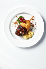 Kiev cutlet with mashed potatoes and a sprig of red currants on a light plate, white background copy space, original serving of Kiev cutlet, top view
