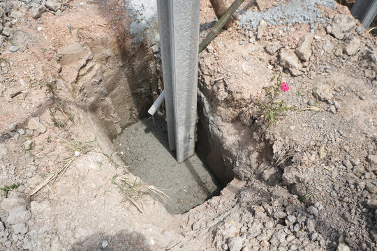 Concrete footings and i beam concrete pile for fences that are installed non-standard. The pole is not in the center of the base of the hole.