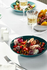 A salad of liver, vegetables and berries, on a festive table with flowers, wine and other snacks, fried veal liver in a salad.