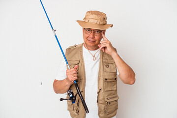 Senior american fisherman holding rod isolated on white background pointing temple with finger, thinking, focused on a task.