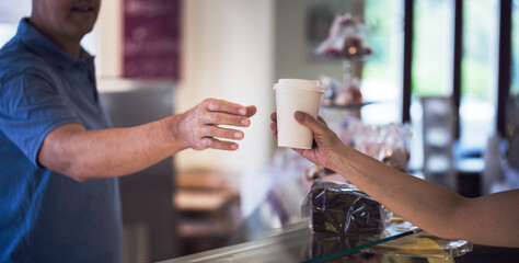 Mann erh&auml;lt Cafe to Go in einen Laden 