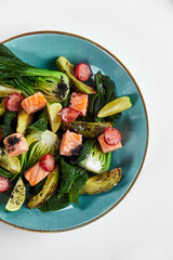 Salmon with artichokes, avocado, close-up, served by the chef with baked salmon and avocado with artichokes in lemon sauce