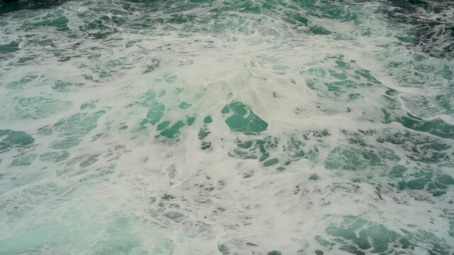 Great view of the sea waves up close during a storm. The waves roll and seethe beautifully, the white foam creates an incredible pattern on the water. Slow motion shooting