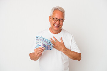 Senior american man holding bill isolated on white background laughs out loudly keeping hand on...