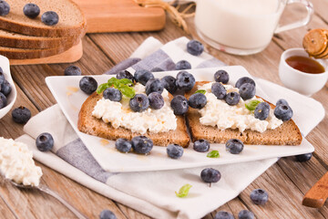 Rye bread with cottage cheese, blueberries and honey.