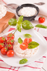 Rice cakes with milk flakes and tomato.