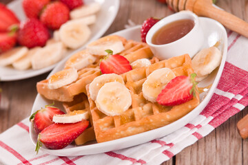 Waffles with strawberries, bananas and honey.