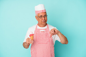 Senior american ice cream maker holding an ice cream isolated on blue background showing a dislike gesture, thumbs down. Disagreement concept.
