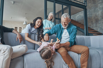 Happy family spending time together and smiling while sitting on the sofa at home