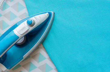 Still life of an iron on an ironing table and a woman's suit

