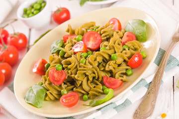 Fusilli pasta with cherry tomatoes and peas.