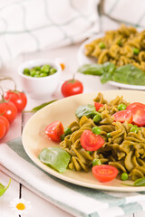 Fusilli pasta with cherry tomatoes and peas.