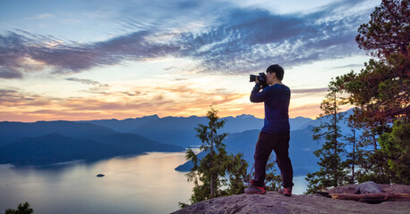 Adventure Photographer Hiking and taking pictures of Canadian mountain landscape during colorful...