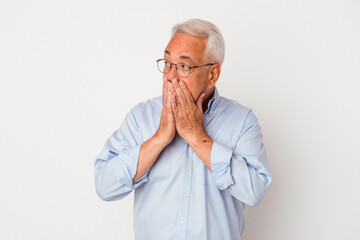 Fototapeta premium Senior american man isolated on white background thoughtful looking to a copy space covering mouth with hand.