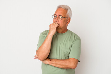 Senior american man isolated on white background suspicious, uncertain, examining you.