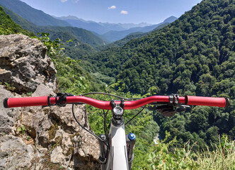 Bicycle handlebar at mountains background. Downhill race on mountain bike