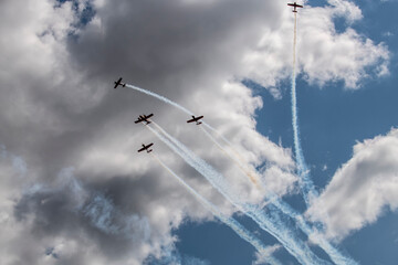 a beautiful plane makes a difficult turn leaves a white trail of flight against the background of the sky