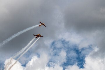 a beautiful plane makes a difficult turn leaves a white trail of flight against the background of the sky