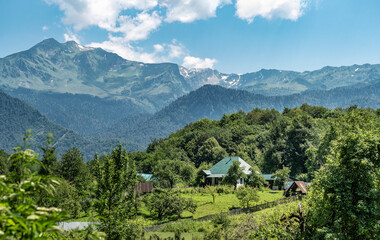 Fototapeta na wymiar Village at panoramic mountains background at sunny summer day