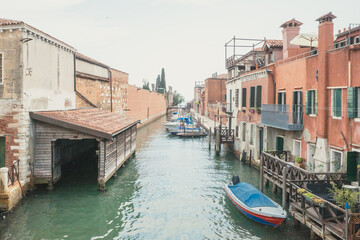 Fototapeta na wymiar Narrow canal by traditional Venetian houses on island of Giudecca, Venice, Italy