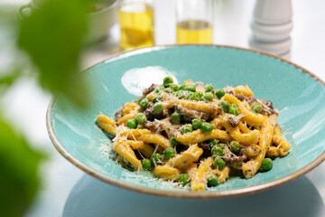 Pasta with green peas, mushrooms, and Parmesan cheese.
The cook cooks and serves an appetizing...