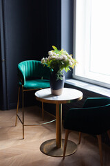 Two green chairs in a dark classic cafe room. Decor for a catering establishment