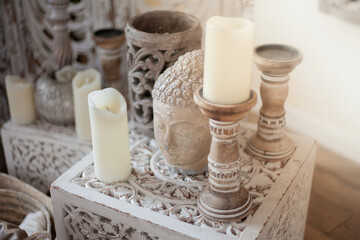 The Buddha's head made of stone and candles in the interior design of the room. Ethnic Esoteric boho Indian Home Decor