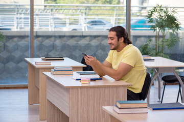 Young male student sitting in the classroom