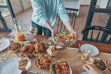 Close-up of woman serving meal on table during family gathering