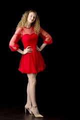 Smiling blonde curly girl posing in red dress