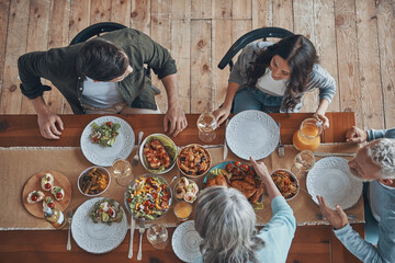 Top view of multi-generation family communicating while having dinner together