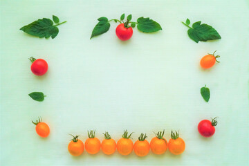 新鮮な赤と黄色のミニトマトと葉っぱを使ったフレーム風背景