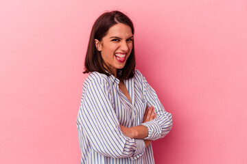 Young caucasian woman isolated on pink background funny and friendly sticking out tongue.