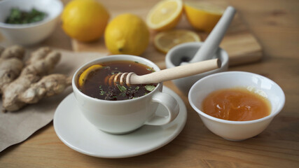 Put a teaspoon of honey in a Cup of hot tea with lemon. Close up.