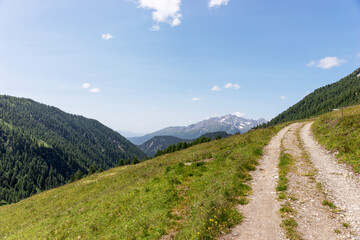 Naklejka na ściany i meble Alpine small mountain road and hiking trail path in the alps