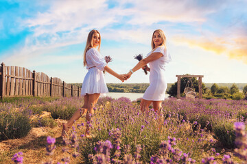 Portrait of two attractive woman's, mom and adult daughter, family time at lavender field in the summer