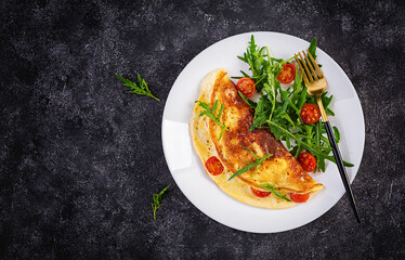 Breakfast. Omelette with tomatoes, cheese  and salad on white plate.  Frittata - italian omelet. Top view