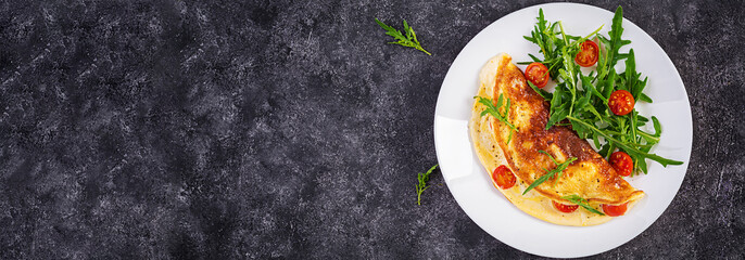 Breakfast. Omelette with tomatoes, cheese  and salad on white plate.  Frittata - italian omelet. Top view, banner