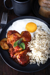 Combination dish: fried egg, zucchini with tomato and brown rice. Vegetarian Food. Photograph of ready-to-eat food plate