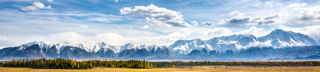 Scenic mountain range in sunlight and blue sky with clouds. Popular tourist destination in Altai Mountains. Kurai steppe in autumn.