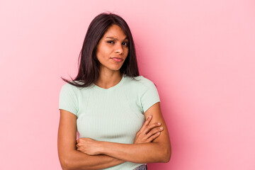Obraz premium Young latin woman isolated on pink background suspicious, uncertain, examining you.