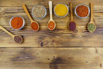 Fototapeta na wymiar Set of different aromatic spices on wooden table. Top view, copy space