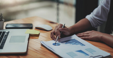 business woman working on laptop computer with business graph