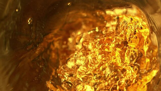 Super slow motion of pouring whiskey, rum or cognac inside the bottle. Speed ramp effect. Filmed on high speed cinema camera, 1000fps