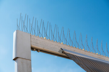 isolated detail of a steel barbed repellent used on structures such as awnings, sales and building cornices to deter pigeons and other birds