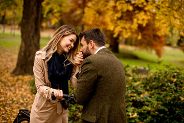 Young couple in the autumn park with electrical bicycle