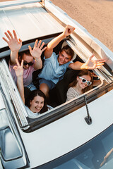 group of friends in car looking up through sunroof