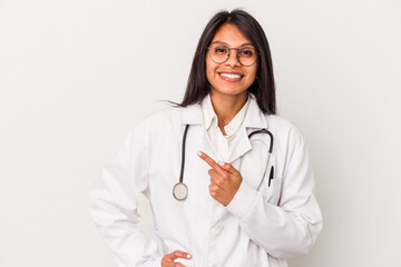 Young doctor latin woman isolated on white background smiling and pointing aside, showing something at blank space.