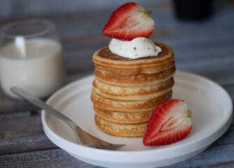 Clear view of Stack of pancakes with honey stick, strawberry, blue berry and whip cream on top in...